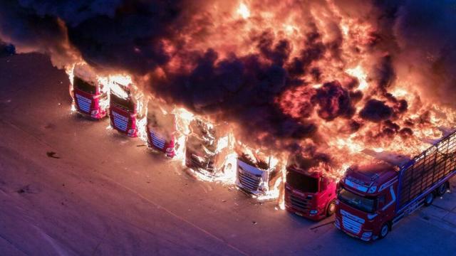 Burning trucks close