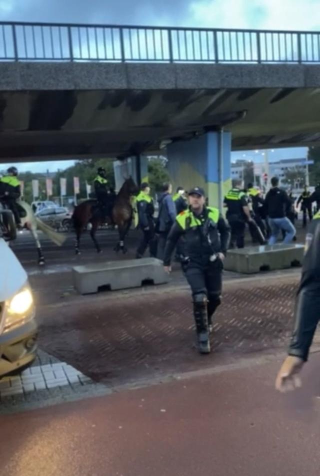 2 politie te paard, meer dan 10 agenten, links een politiebusje, onder viaduct